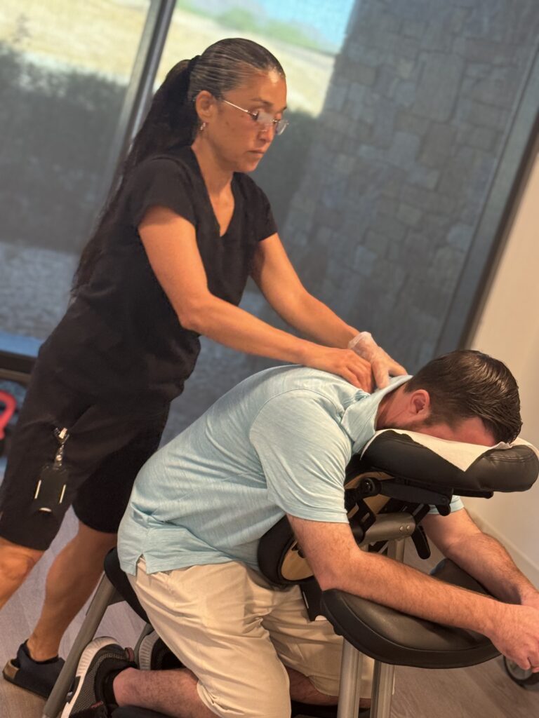 A woman receives a relaxing massage from a man, promoting stress relief and enhancing productivity in a serene environment.