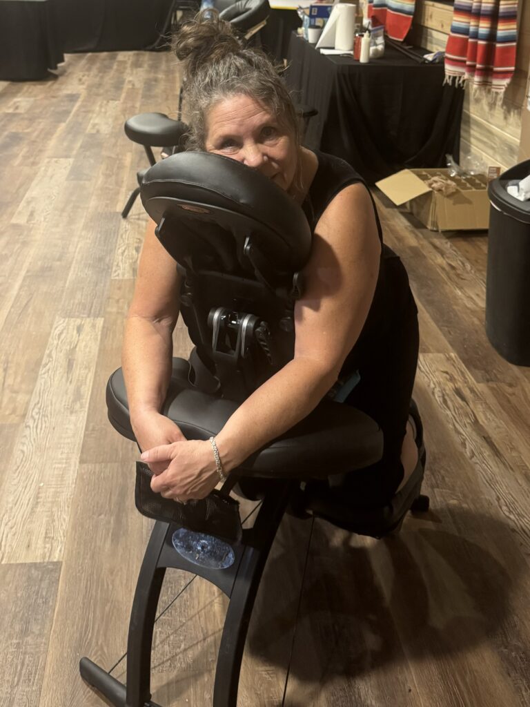 A woman relaxes in a massage chair, enjoying a soothing experience in a tranquil room setting.