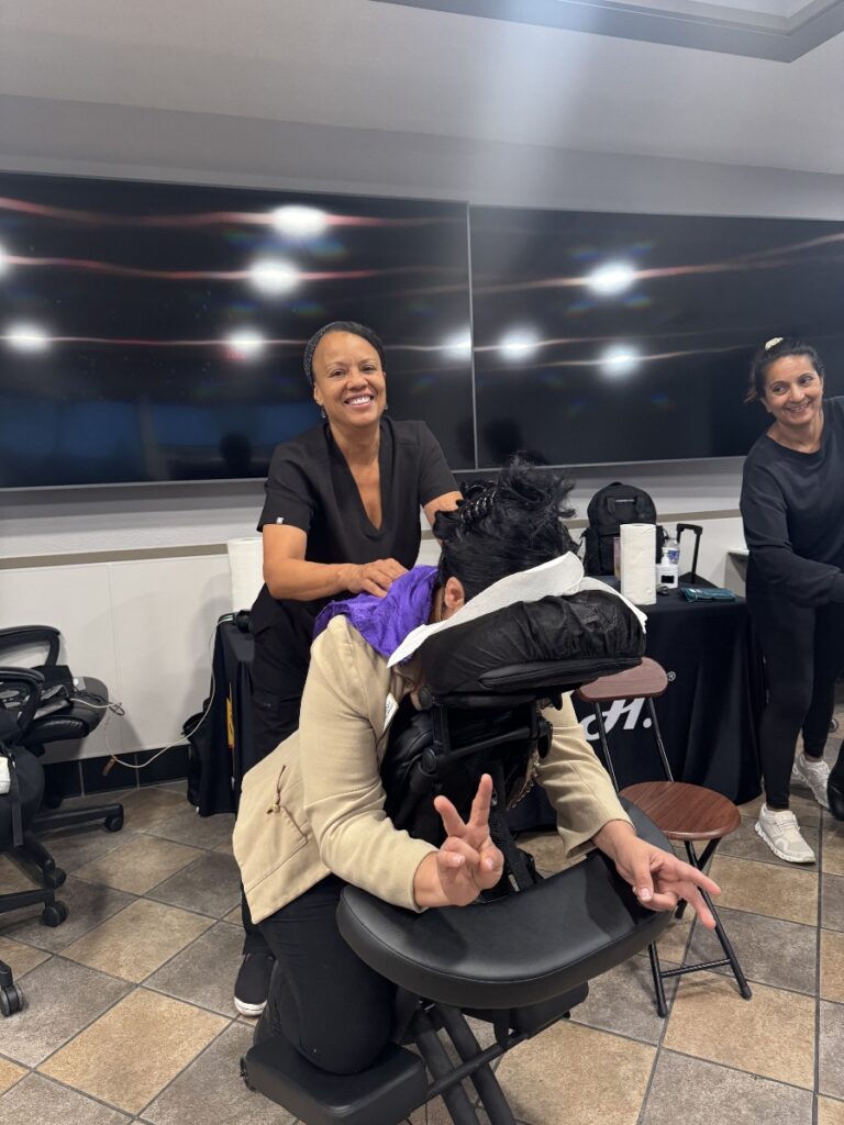 A woman receives a hair styling treatment from another woman, showcasing a moment of personal care and relaxation.