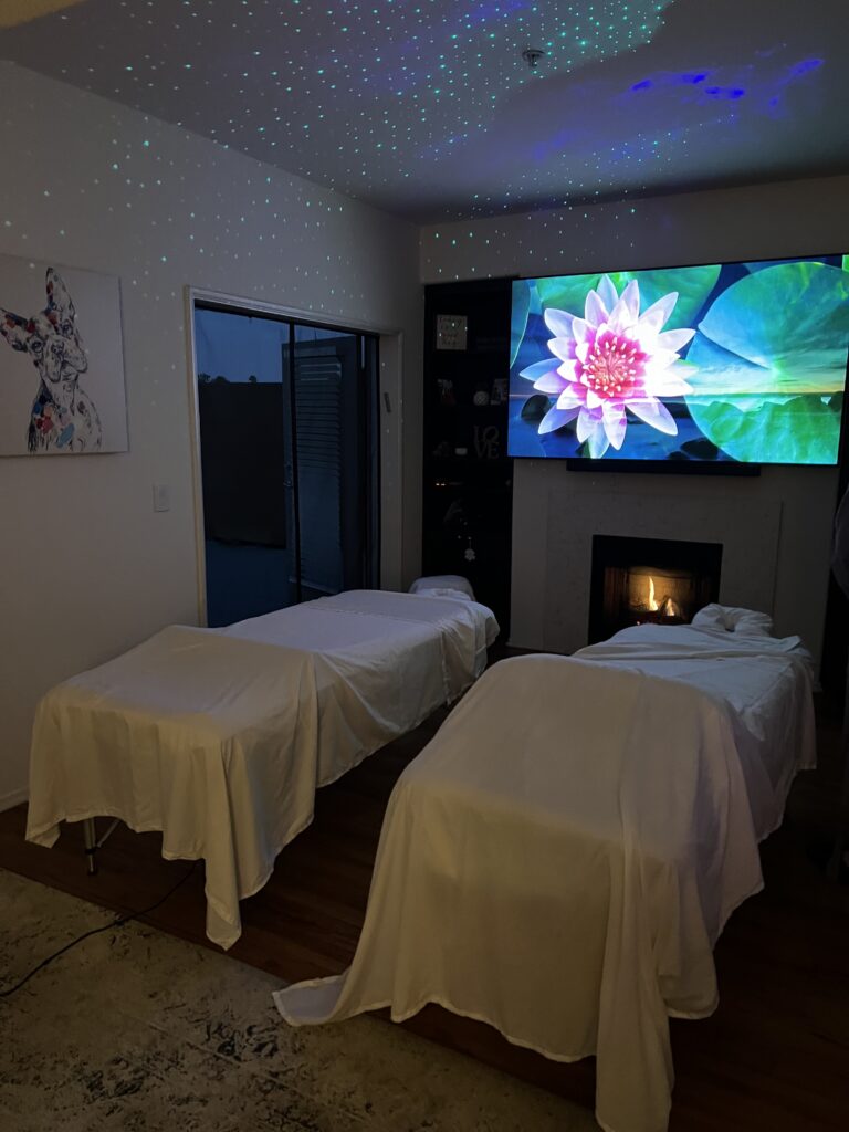 A cozy room featuring two beds and a wall-mounted TV, ideal for relaxation and comfort during a spa retreat.